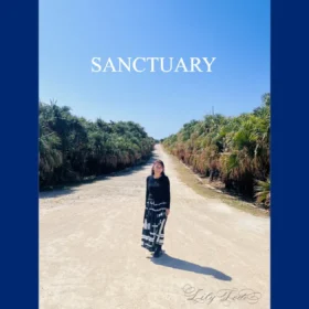 琉球最高の聖域・久高島で、カベール岬へ続く並木道に立つ、久高島区長認定ガイドのLily Todo（東道里璃）。空間の安寧（SANCTUARY）を創り出す琉球風水空間デザインの専門家としての肖像。